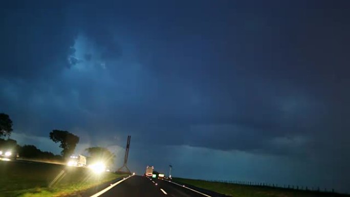 夜间公路旅行时雷暴闪电。夜间在雨天道路上行驶时雷暴雷击。在4k行驶时下雨和打雷