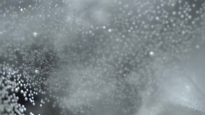 Bubbles on glass with sparkling water in rotation