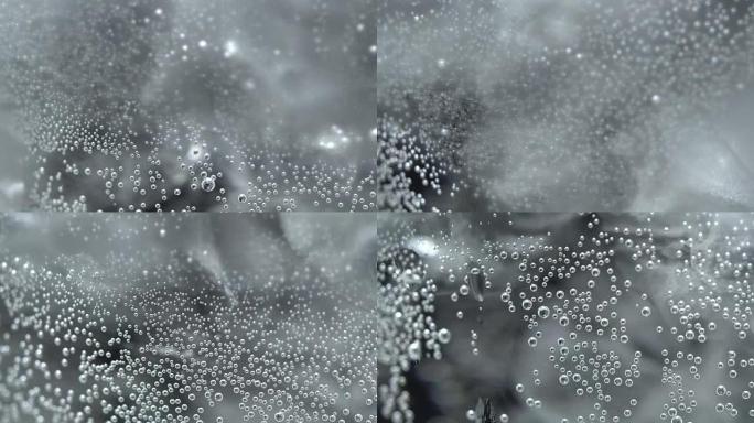 Bubbles on glass with sparkling water in rotation