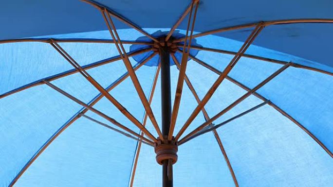 室外蓝色遮阳伞，游泳池水波纹反射阳光