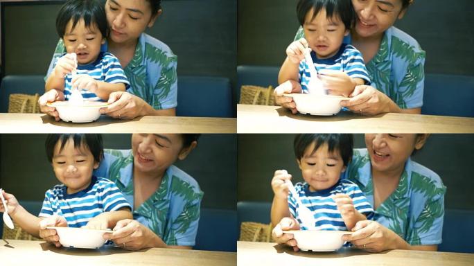 亚洲男婴与妈妈一起吃饭和玩耍