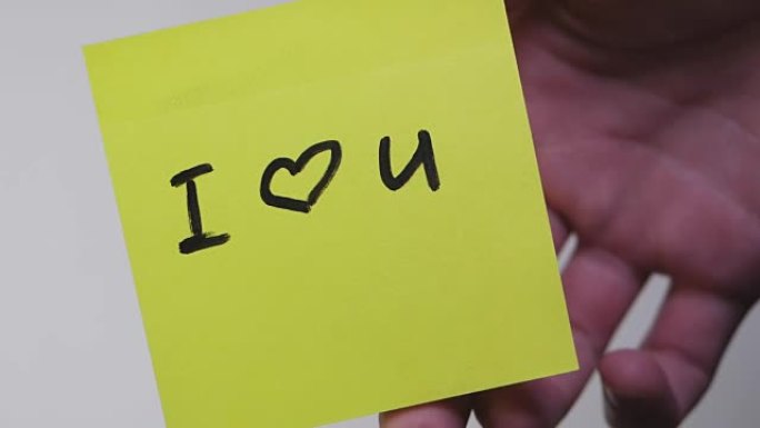 贴纸上的铭文我爱你。在黄纸上画 “我爱你” 和心。题词我爱你在玻璃上的贴纸