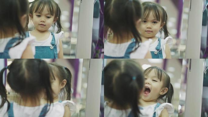 泰国女童用镜子的倒影使自己的脸变得幽默