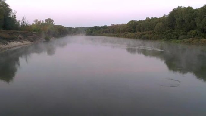 黎明时河流的航拍。旭日背景下从河中升起的薄雾