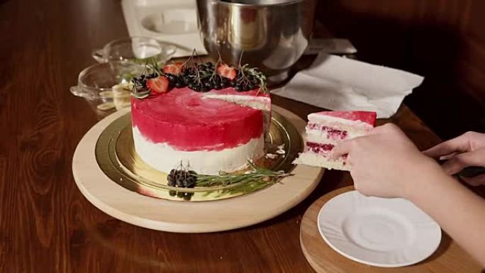 一个女人切的甜蛋糕的特写镜头，将其切成薄片放在盘子上