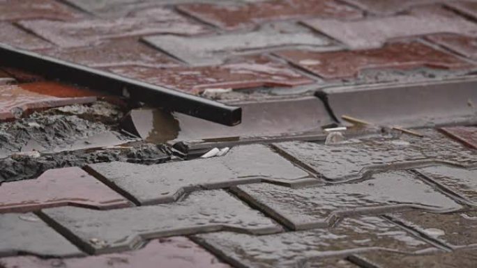 雨滴落在运动场的水坑中，倾盆大雨关闭。暴雨期间，洪水泛滥的城市街道上的水滴和飞溅。潮湿表面的反射。雨