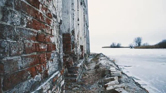 在冰冻的湖中摧毁了旧建筑的红砖墙