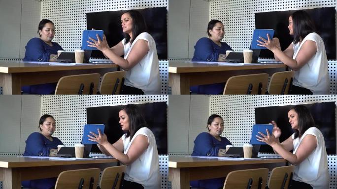 商务女性在会议上分享平板电脑上的信息