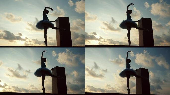 芭蕾舞短裙和尖角芭蕾舞演员的剪影在戏剧性的天空背景上。年轻漂亮的女人练习伸展运动。静态姿势的女孩。慢