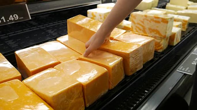 超市内女人手工采摘奶酪的动作