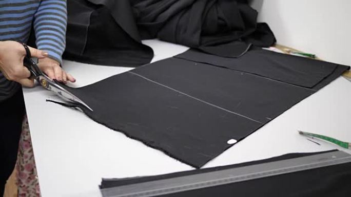 纺织，工作室工人在白色桌子上切割黑色织物