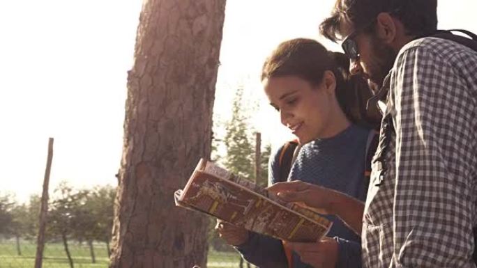 快乐的年轻夫妇背包客游客阅读地图指南，在罗马公园的罗马渡槽拱门附近迷失方向