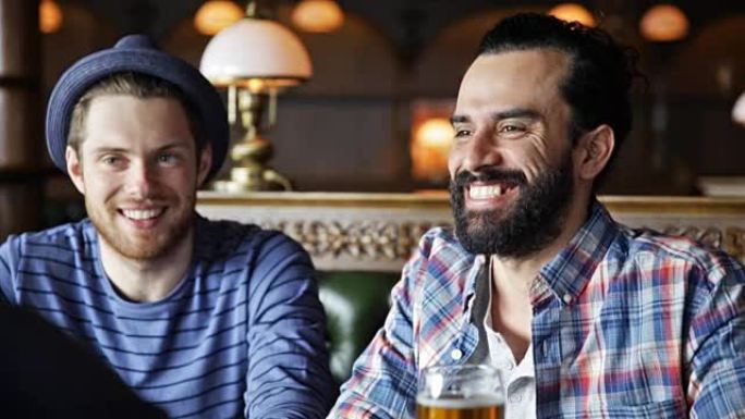 快乐的男性朋友喝啤酒，在酒吧或酒吧聊天