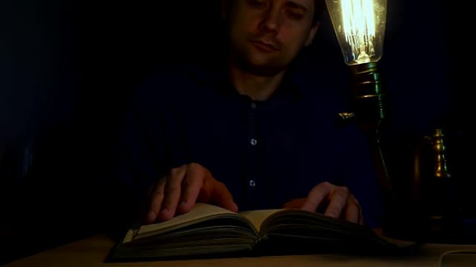 男人晚上用老式灯看书。