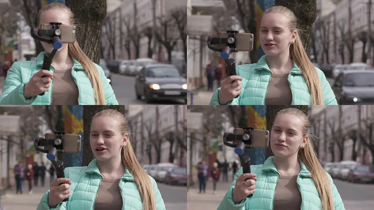 带手机摄像头稳定器的女孩视频记录器为视频日志制作视频
