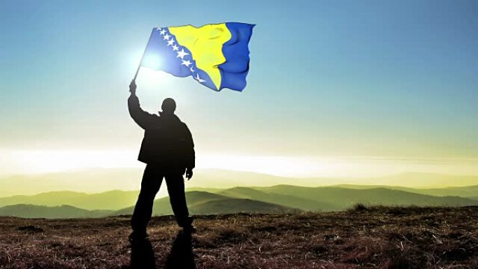 成功的运动员在山顶挥舞着波黑国旗。Cinemagraph循环背景