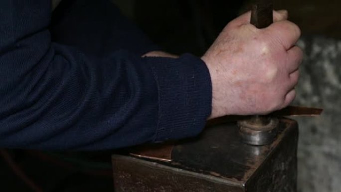 在铜匠的车间里: 用锤子敲打铁砧上的铜板