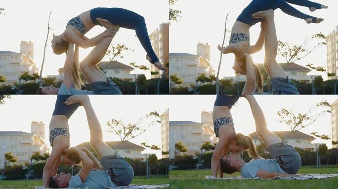 年轻夫妇在公园日落时练习acro瑜伽
