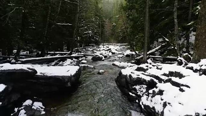 积雪覆盖的冰冻巨石沿河床流水