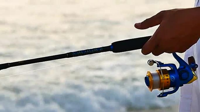 日常生活视频特写钓鱼的手是在热带海洋中使用钓鱼钩。
