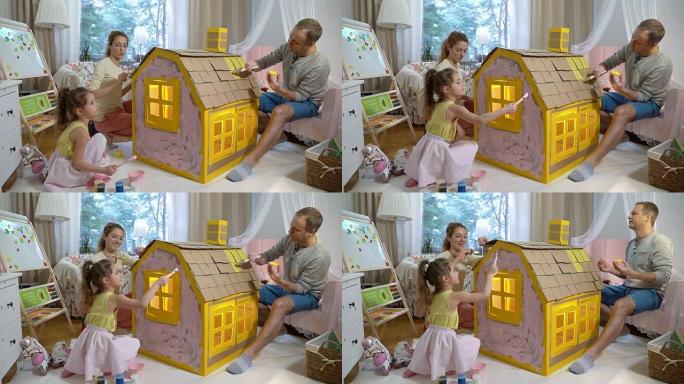 Young family with child building and painting toy 