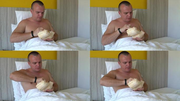 男人躺在床上，用勺子吃年轻的椰子