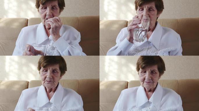 不健康的老妇人吃药，喝水。