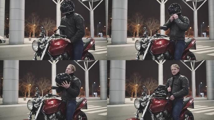 年轻有魅力的摩托车手，戴着头盔和定制摩托车在夜街上