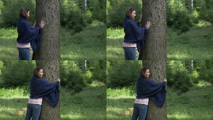 年轻的自然主义者女人在山上徒步旅行中拥抱美丽的树，热爱自然概念