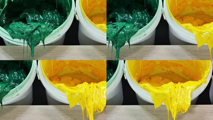 白色塑料罐中的塑料溶胶墨水的绿色黄色和红色