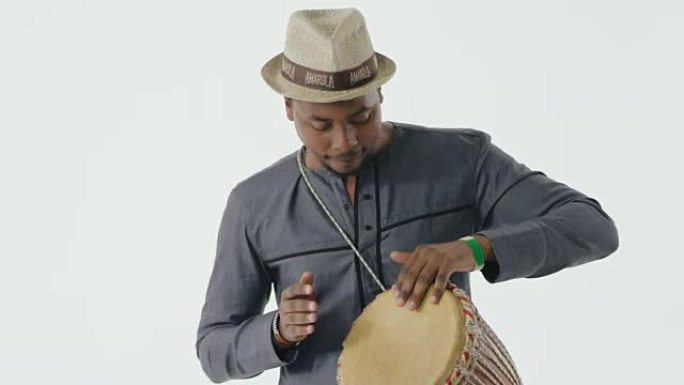 在专业非洲djembe鼓上演奏的特写音乐家