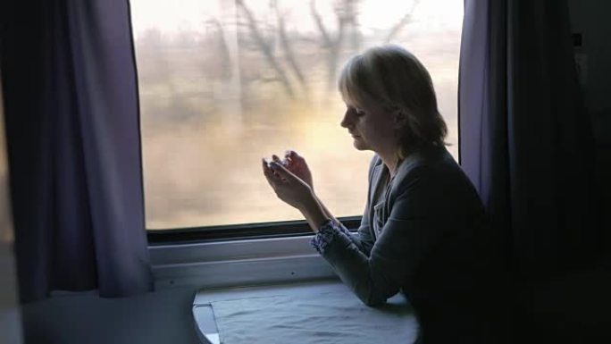 女商人使用智能手机，在火车车厢中旅行