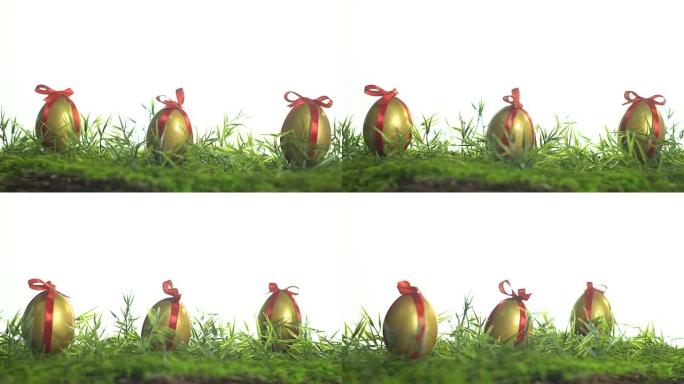 绿色草地上用红丝带绑着金色油漆的鸡蛋