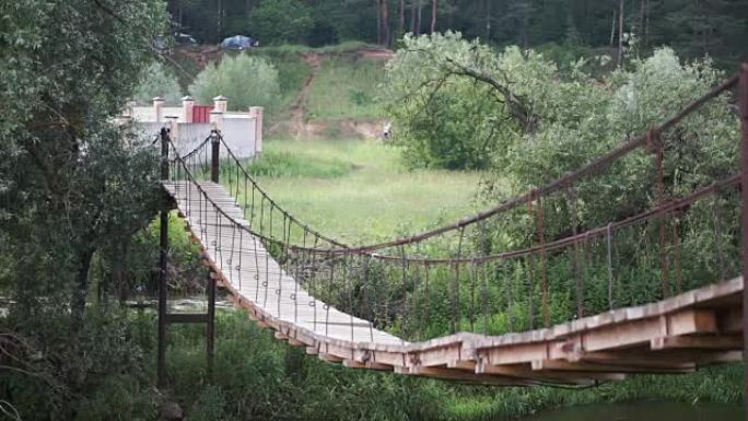 公园里的木桥。夹。通往雨林的绳索走道。穿越沼泽的旧木桥。悬吊木桥跨河到秋林