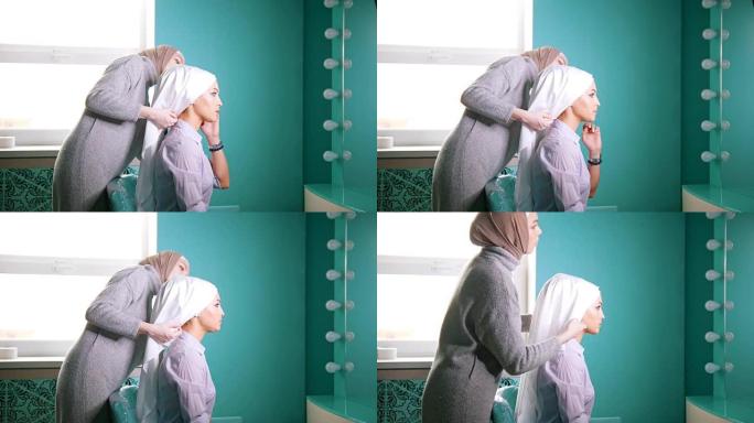 一名穆斯林妇女为穆斯林新娘绑头巾