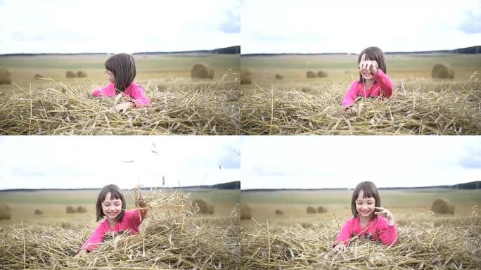 快乐的漂亮女孩用吸管涉猎，在田野里微笑