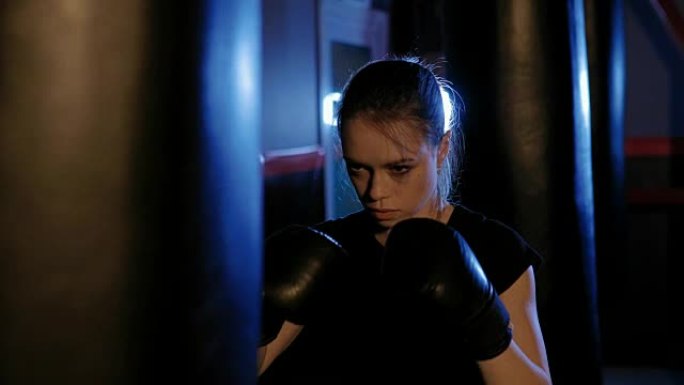 女孩是拳击。美丽的跆拳道女子训练沙袋。女斗士的拳头靠近。