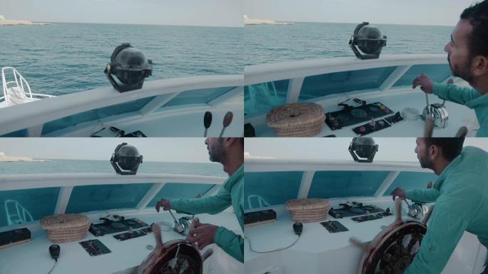 埃及-2018年1月。游艇的船长使用指南针进行导航。他对着蓝色的海洋转动方向盘。管理生活、商业的概念