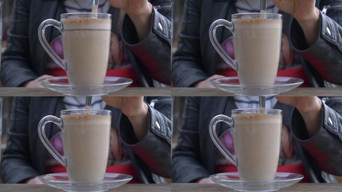 一个女孩坐在咖啡馆里。喝咖啡。特写