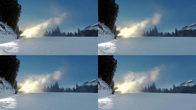 黄色的雪炮在冬天顶着太阳站在雪山上，并在美丽的山脉，白雪覆盖的松树和滑雪场的背景下产生一列雪