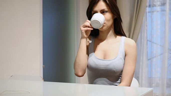 年轻女子喝热咖啡，坐在家里