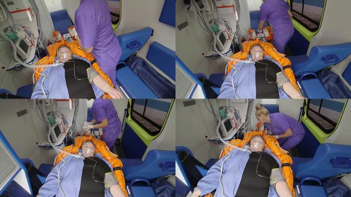 紧急医疗服务。女性EMS护理人员在救护车中治疗患者