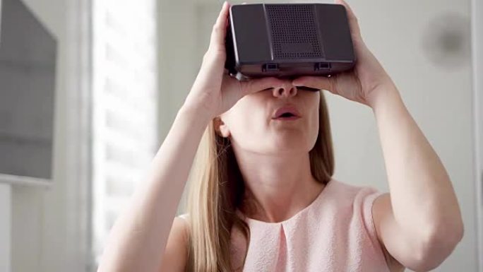 现代年轻漂亮的女人在家里使用VR虚拟现实360眼镜。未来是女性概念