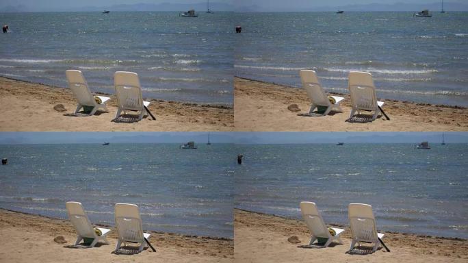 海滩上的两把空塑料椅子