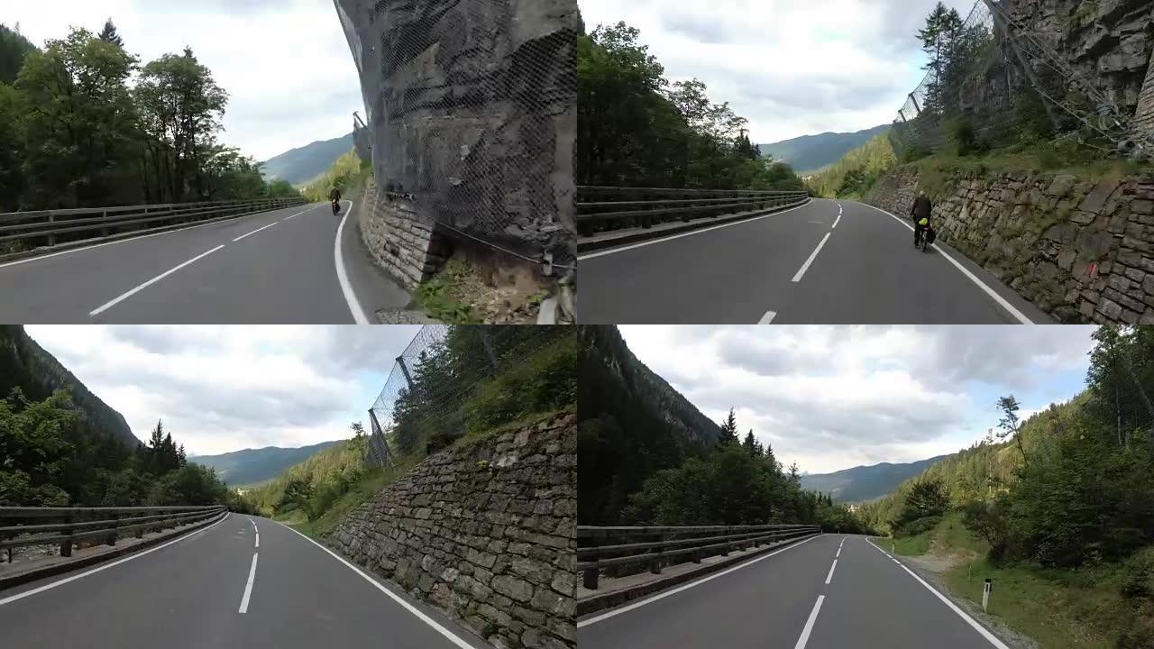 摩托车手骑在奥地利美丽的风景山路上。第一人称视角