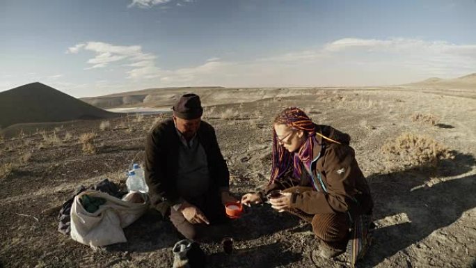 在干旱的山区，牧羊人用糖给一个紫色辫子的女孩喝茶