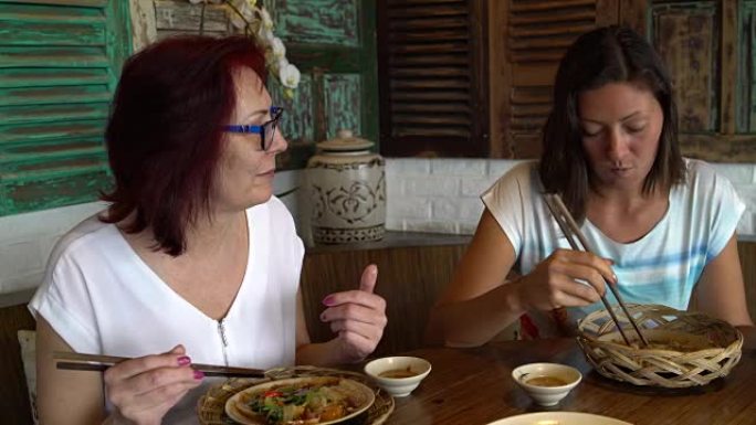 女人在餐厅吃海鲜和鸡肉串聊天