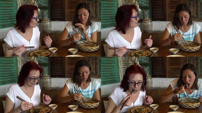 女人在餐厅吃海鲜和鸡肉串聊天