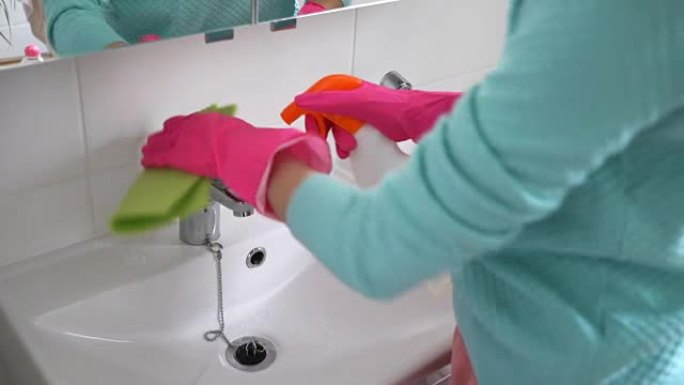 戴橡胶手套的女人打扫浴室的水槽