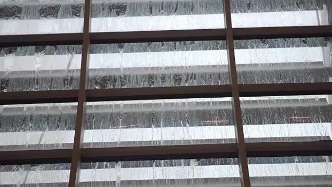玻璃屋顶上的雨滴。从底部看，雨滴飞溅并流到玻璃上。慢动作。3840x2160